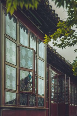 Döşeme çatılı ve karmaşık desenli pencereli geleneksel bir Çin binası..