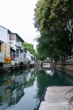 Suzhou, Çin - 11 Haziran 2024: Çin 'in Suzhou kentindeki geleneksel binaların bulunduğu bir kanal manzarası.