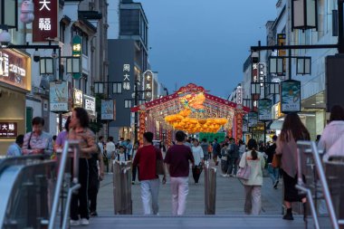 Suzhou, Çin - 11 Haziran 2024: Çin 'de Suzhou, Çin' de kalabalık bir şehir caddesi, fenerlerle süslenmiş bir festival kemer yolu ve yanından geçen bir kalabalık.