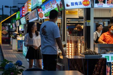 Suzhou, Çin - 11 Haziran 2024: Çin 'in Suzhou şehrinde bir sokak yemeği satıcısı, bir çifte ızgara et şişi satıyor.