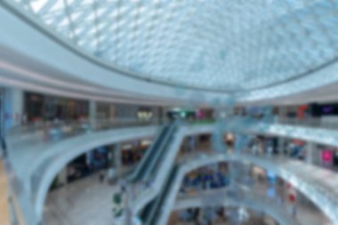 Shenzhen, Çin 'de cam tavan ve yürüyen merdivenlerin yer aldığı modern bir alışveriş merkezinin bulanık ve soyut bir görüntüsü.