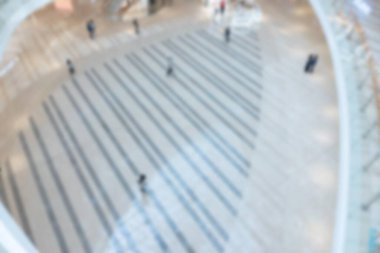 Shenzhen alışveriş merkezinin fayanslı zemininde yürüyen insanların bulanık görüntüsü. Görüntü bulanık, bokeh efektleri oluşturuluyor.