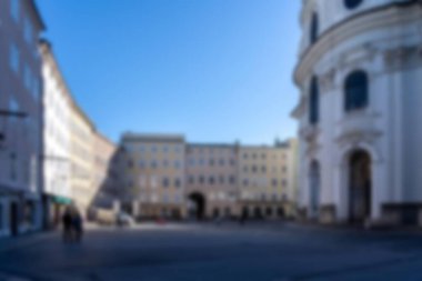 Avusturya, Salzburg 'daki bir sokak manzarasının bulanık görüntüsü. Kemerli girişi olan beyaz bir bina..