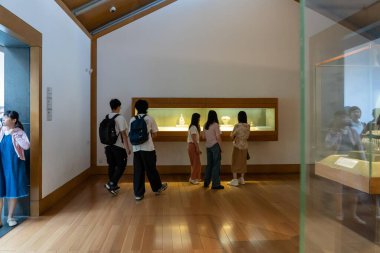 Suzhou, Çin - 12 Haziran 2024: Bir grup insan bir müzede eserlere bakıyor. Bazı ziyaretçiler sırt çantası takıyor..