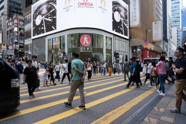 Hong Kong, Çin - 3 Temmuz 2024: Kalabalık bir Hong Kong şehrinde yayalar caddeyi geçerken yoğun bir yaya geçidi.