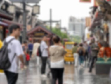 Çin 'in Hangzhou şehrinde sokakta yürüyen insanların bulanık görüntüsü. Sahne Bokeh 'te bir hareketle çekiliyor..