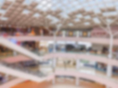 Yürüyen merdivenli çok katlı bir alışveriş merkezinin bulanık görüntüsü.