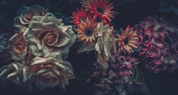 Karanlık ve kasvetli bir ortamda klasik yapay çiçekler..