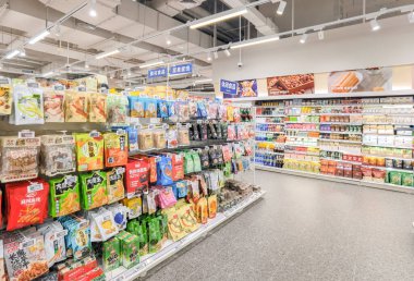 Shenzhen, Çin - 25 Ekim 2024: Shenzhen, Çin 'de çeşitli abur cubur ve paketlerle dolu modern bir süpermarket koridoru.