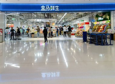 Shenzhen, Çin - 25 Ekim 2024: Shenzhen, Çin 'de kalabalık bir süpermarket girişi, müşteriler koridorlarda geziniyor ve çalışanlar rafları dolduruyor.