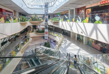 Shenzhen, Çin - 25 Ekim 2024: Camdan tavanı ve yürüyen merdivenleri olan modern bir alışveriş merkezi.