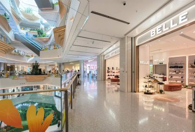 Shenzhen, Çin - 25 Ekim 2024: Temiz, minimalist bir tasarıma sahip, çok katlı ve çeşitli perakende mağazaları olan geniş, açık bir alana sahip modern bir alışveriş merkezi.