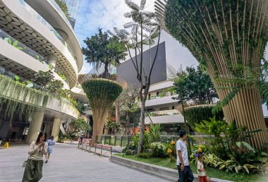 Shenzhen, Çin - 25 Ekim 2024: Shenzhen, Çin 'deki modern bir alışveriş merkezi, yemyeşil ve yükselen palmiye ağaçları ile benzersiz bir tasarıma sahiptir..