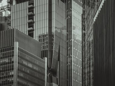 Bir Hong Kong şehir manzarası, tek renkli yakın çekim ile çekildi. Yoğun gökdelenler yükseliyor, mimari ayrıntılar ve kentsel yoğunluk sergileniyor.