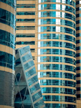 Close-up view of modern Hong Kong skyscrapers.  Geometric glass facades and architectural details dominate the image, showcasing a dense urban landscape. clipart