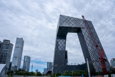 Pekin, Çin - 17 Eylül 2025: İkonik CCTV Merkezi, çarpıcı bir ticari bina, şehir siluetini demirliyor. Dramatik bulutlu gökyüzü altında eşsiz modern mimari.