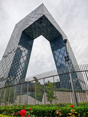 Pekin, Çin - 17 Eylül 2025: Belirgin bir ticari bina, CCTV Genel Merkezi, bulutlu bir gökyüzüne karşı eşsiz döngü mimarisini ve yansıtıcı cam cephelerini sergiliyor.