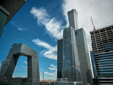 Pekin, Çin - 17 Eylül 2025: Canlı bir mavi gökyüzü, modern kentsel mimarinin sergilendiği ikonik CCTV Karargahını ve çok sayıda gösterişli ticari binaları çerçeveledi.