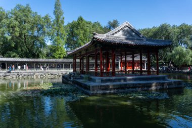 Sep 19, 2025 - Pekin, Çin: Turistler geleneksel Pekin mimarisi ve bahçelerinin sergilendiği bir Qing hanedanlığı müzesi olan tarihi Prince Gong Malikanesi 'nde manzaralı bir su geçidi boyunca geziniyorlar.