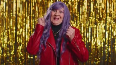 Ceketli mutlu bir kadın bağırıyor, el kol hareketi yapıyor başarıyı kutluyorum, kazanıyorum, doğum günü, piyango hedefine ulaşıyorum. Parlak disko partisi geçmişi olan yaşlı bir büyükanne.