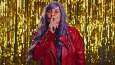 Sessiz olun lütfen. Şık, yaşlı bir kadının portresi işaret parmağını dudaklara bastırıyor. Sessizlik işareti gizli tutulmasını sağlıyor. Parlak disko partisi geçmişi olan yaşlı, olgun bir büyükanne.