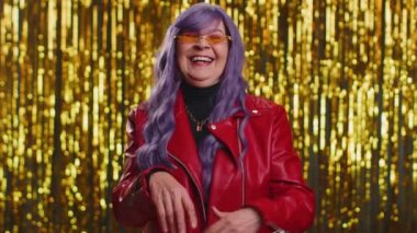 Komik anekdotlar, komik şakalar duyduktan sonra yüksek sesle gülen, mor peruklu neşeli kadın, kaygısız, neşeli, pozitif insan yaşam tarzı. Parlak disko partisi geçmişi olan yaşlı bir büyükanne.