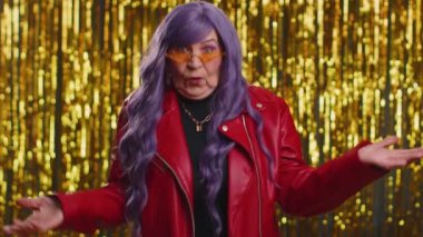 Neden? Öfkeli bir ifadeyle el kaldıran samimi, sinirli, yaşlı bir kadın başarısızlığının nedenini sorarak sorunlardan rahatsız olduğunu gösteriyor. Parlak arka planda kafası karışmış bir büyükanne.