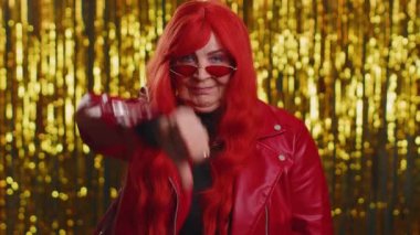 Hoşlanmamak. Üzüntülü, ceketli, mutlu olmayan olgun bir kadın. İşaret işareti yapıyor. Hoşnutsuzluğunu, memnuniyetsizliğini, hoşnutsuzluğunu ifade ediyor. Yaşlı büyük anne. Parlak arka planda kapalı stüdyo