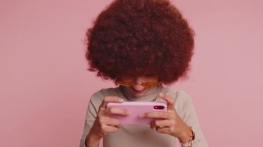 Endişeli genç kız çocuk heyecanlı bir şekilde akıllı telefondan yarış oynuyor ya da video oyunu oynuyor. Heyecanlı küçük sevimli çocuklar mobil telefon aygıtı kullanıyorlar.