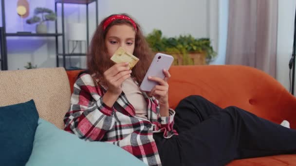 Tenåringsjente Som Bruker Kredittkort Smarttelefon Mens Hun Overfører Penger Kjøper – stockvideo