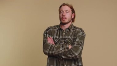 Dissatisfied man shaking head no, asking reason of failure, expressing disbelief irritation, feeling bored, disappointed in result, bad news. Adult guy isolated alone on beige studio wall background
