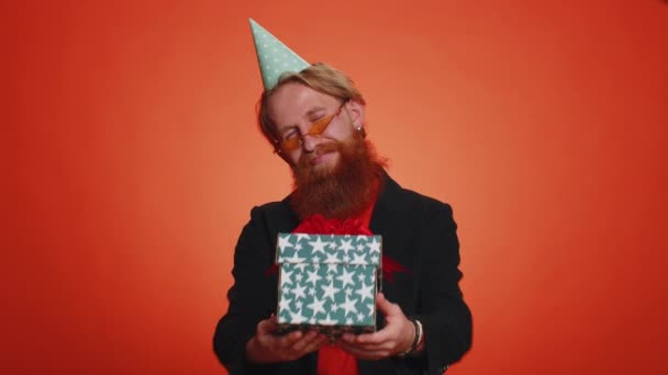 Positivt Leende Skäggig Man Presenterar Födelsedagspresent Box Sträcker Händerna Erbjuder — Stockvideo