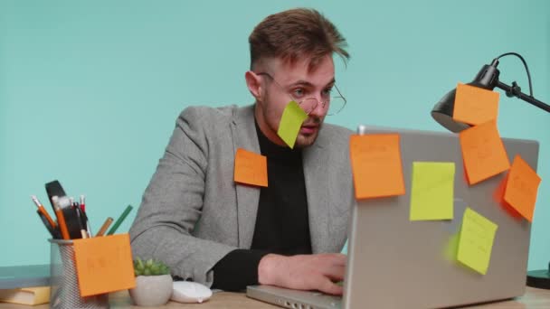 피곤에 사업가 사무실 책상에 작업에 도움이 노트북 끈적끈적 지폐를 붙이고 — 비디오