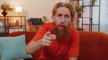 Hey sen! Kafkas sakallı bir adamın portresi heyecanla gülümsüyor ve kamerayı işaret ediyor, şanslı kazananı seçiyor, sizi harika gösteriyor, davet ediyor, onaylıyor. Evdeki genç adam turuncu koltukta.