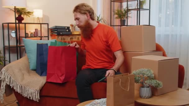 Happy Shopaholic Consumer Man Sitting Shopping Bags Modern Home Apartment — Stock Video