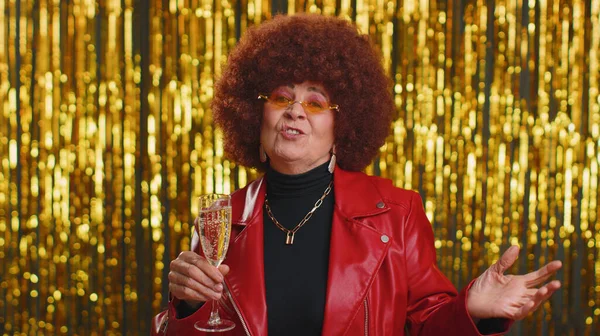 赤いジャケットの面白い女性は音楽を聞いて ディスコパーティー音楽に踊って笑顔 シャンパンを飲み 楽しんでいます 受賞を祝うシニア祖母 誕生日 光沢のある背景に隔離されたXmas — ストック写真