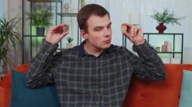 Evde iki altın sikke tutan serbest çalışan adam başarılı bir geliştirici programcı. Hisse senedi tüccarı, online ticaret operasyonlarını izledikten sonra bitcoin kazanıyor. Zenginliğin artması finansal refah