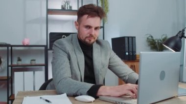 Businessman in suit working on laptop computer shakes finger and saying no, be careful, scolding and giving advice to avoid danger mistake, disapproval sign at office. Confident serious freelancer man