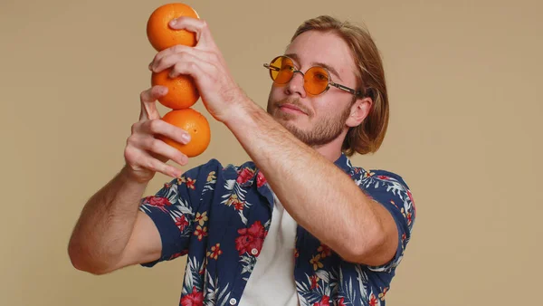 オレンジフルーツ ベジタリアンライフスタイル 健康のためのビタミン 幸せな休暇の休日 有機エコフードを示すハンサムな観光の若者 若いです男男の子絶縁上のベージュスタジオ壁の背景 — ストック写真