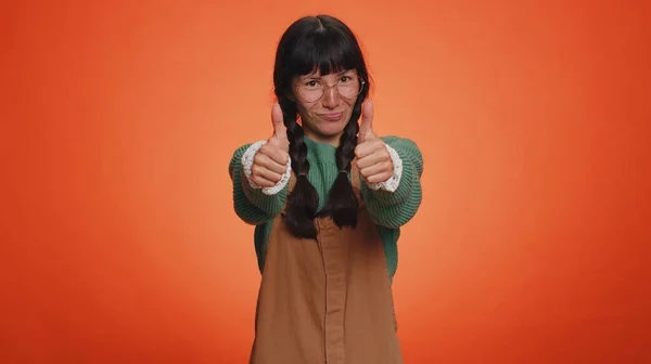 干得好 快乐而快乐的千禧年女人穿着毛衣 竖起大拇指点头表示同意 工作顺利 年轻女孩在橙色工作室背景 人真诚的感情 — 图库照片