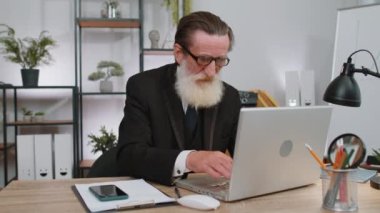 Üst düzey işadamı dizüstü bilgisayarda çalışıyor, meditasyon yapıyor, merkezde Lotus pozisyonunda yoga solunum egzersizi yapıyor. Sakin ve serbest çalışan yaşlı adam ara veriyor. Meşgul bir iş. İç huzuru