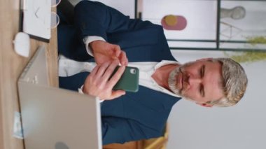 Takım elbiseli yetişkin işadamı akıllı telefon daktilo ile arama yapar, beklenmedik piyango sonuçlarını kaybeder, kötü haber, ofis masasında servet kaybı olur. Orta yaşlı serbest çalışan bir adam.