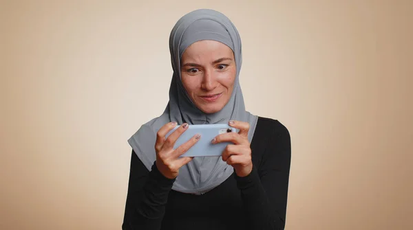 Endişeli Tesettürlü Tesettürlü Müslüman Kadın Cep Telefonuyla Yarış Oyunları Oynuyor — Stok fotoğraf