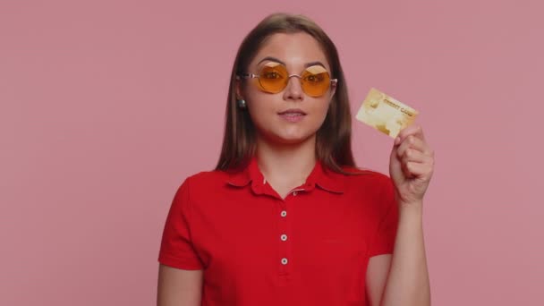 お金のキャッシュレスを転送するプラスチッククレジットカードの広告を示す幸せな観光の女性は オンラインショッピング販売割引 インターネット注文配信購入を購入します 若いです女の子オンピンクの背景 — ストック動画