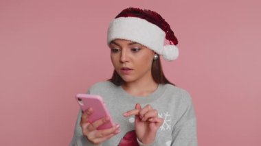 Noel Baba 'lı mutlu kadın Noel Baba süveteri giyiyor cep telefonu kullanıyor. Yazıyor. 