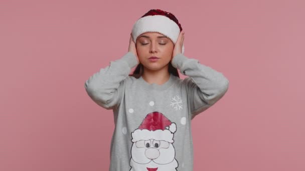 聞き耳を立てたくない いらいらする若いクリスマスの女性は耳をカバーし 不快な騒音の声を無視する助言を避けるために いいえジェスチャーをいらいらさせた 女の子オンスタジオピンクの背景 — ストック動画