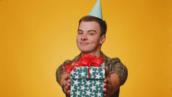 誕生日プレゼントボックスを提示肯定的な笑顔の十代の男性は手を伸ばし 現在のキャリアボーナスをラップ提供し パーティーを祝う 若いですティーン男の子絶縁一人で黄色スタジオ壁の背景に — ストック写真