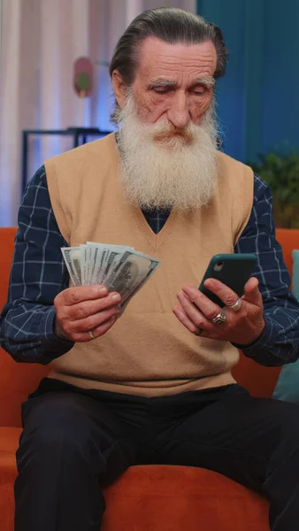 Planowanie Budżetu Rodzinnego Starszy Dziadek Liczył Pieniądze Gotówce Używał Smartfona — Zdjęcie stockowe
