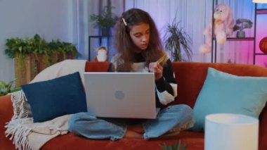 Kredi kartı ve dizüstü bilgisayarı kullanan reşit olmayan bir kızın portresi para transfer ederken, online alışveriş yaparken, eve yemek siparişi verirken. Genç bir çocuk, sınıftaki koltukta oturan bir çocuk.