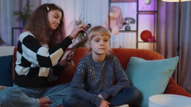 十几岁的孩子和妹妹们用梳子刷孩子们的头发 做发型 兄弟姐妹 孩子或好友在家里的游戏室里梳理长发 友谊家庭关系概念 — 图库视频影像